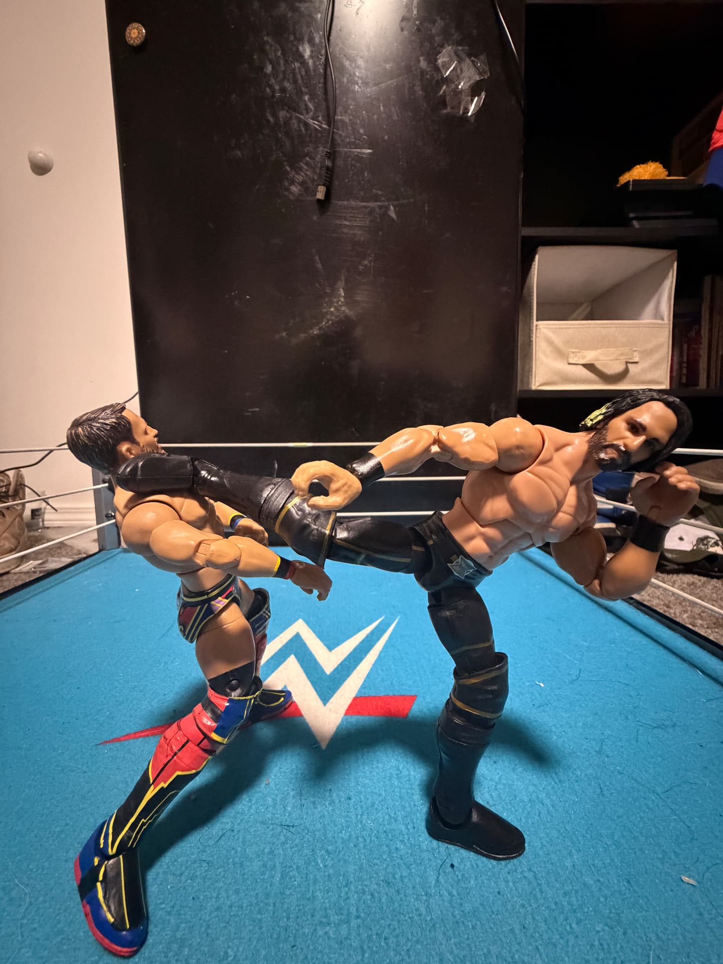 Two wrestling figures exchanging a kick in the ring